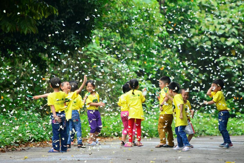 Des enfants jouent avec des papillons au parc national de Cuc Phuong, à Ninh Binh.