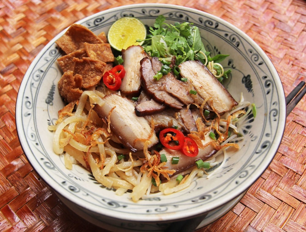 Le Cao Lau est préparé avec des nouilles jaunes, du porc, des crevettes et des légumes frais