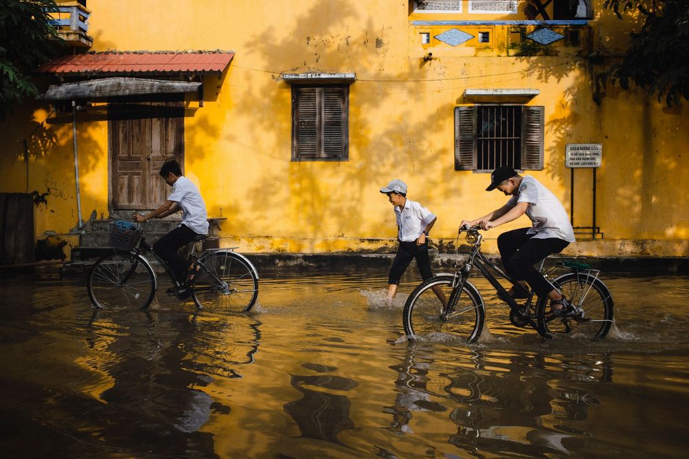 saison des pluies au Vietnam, enfants font du vélo après la pluie, comment s'habiller au Vietnam 