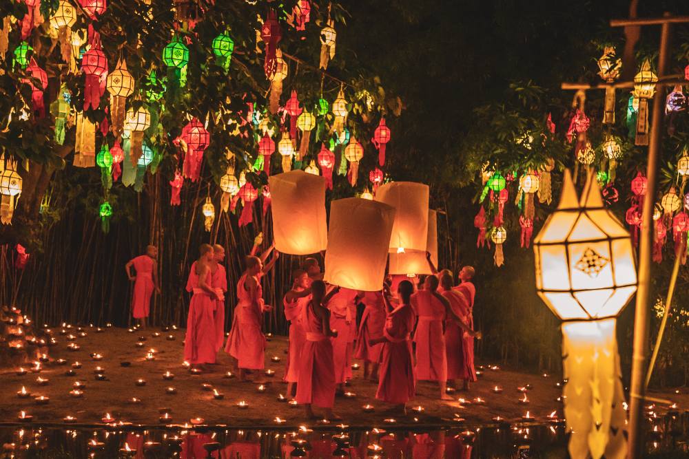 moines bouddhistes lâchant des lanternes dans un temple richement décoré pendant la fête