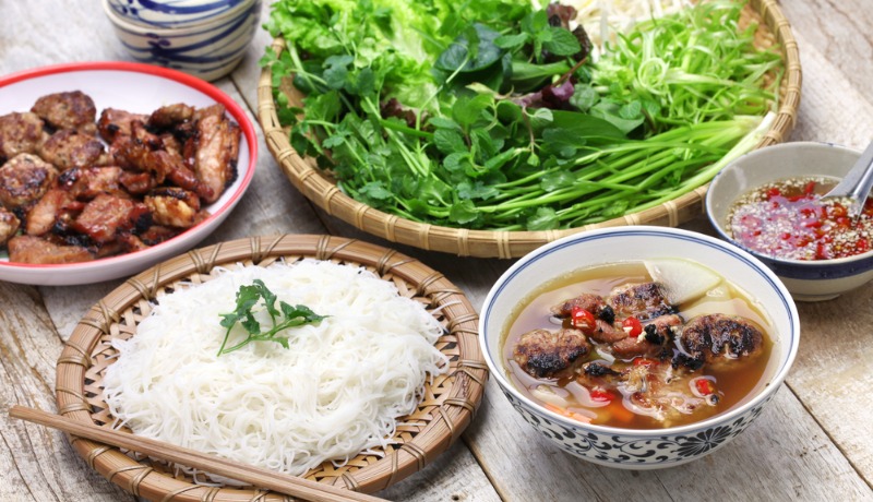 une assiette de Bun Cha à Hanoi avec des vermicelles de riz, du porc grillé et des herbes