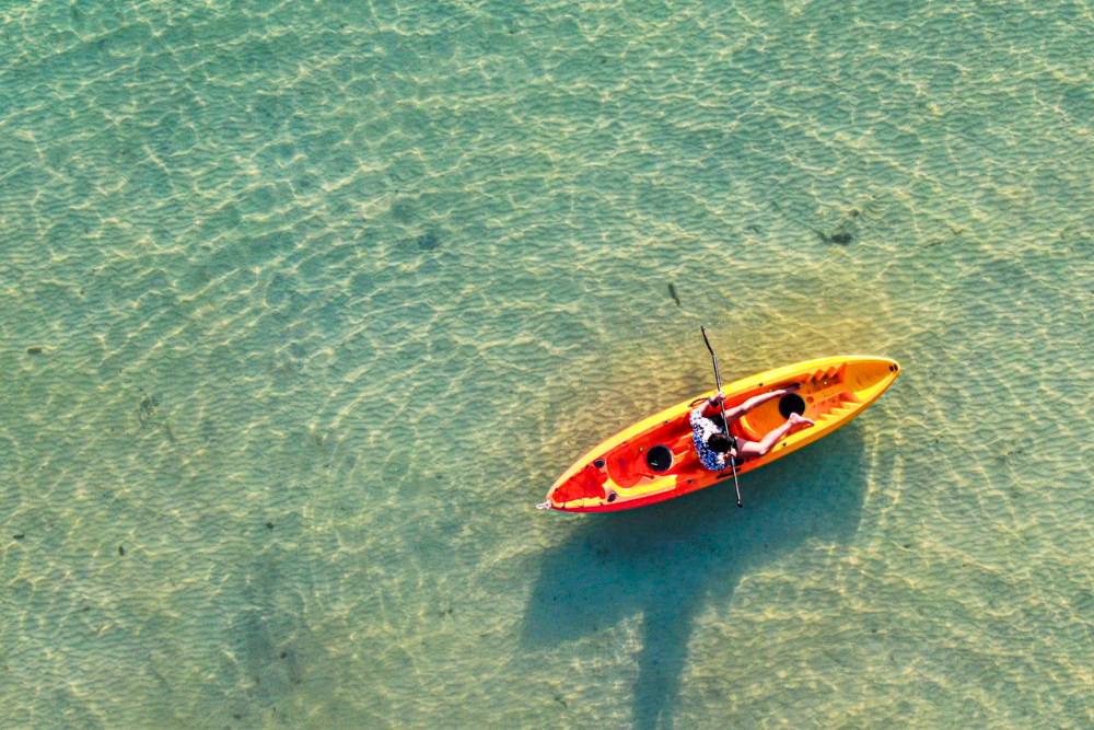 un voyageur faisant du kayak dans la mer bleue claire de Koh Lipe