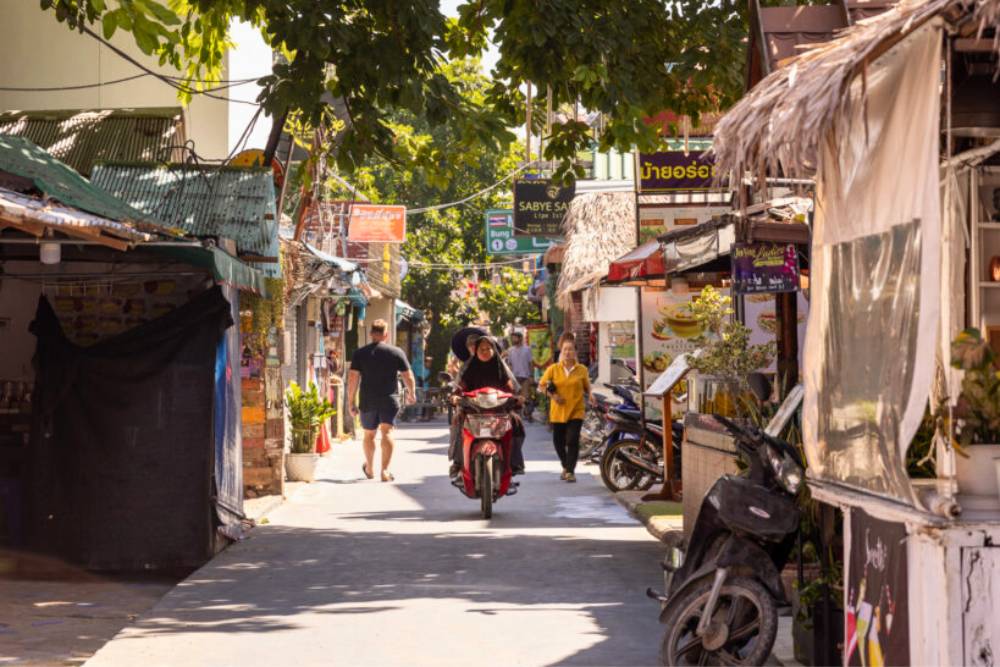 scooters et piétons circulant la rue piétonne Walking Street à Koh Lipe