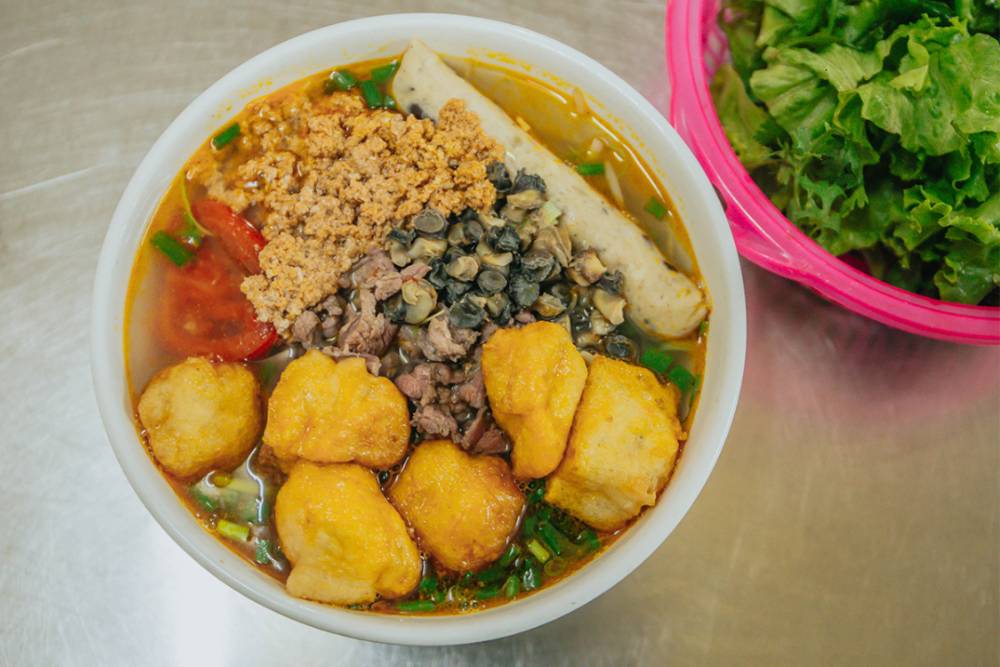 un bol de bun rieu vietnamien avec de la crabe et des escargots