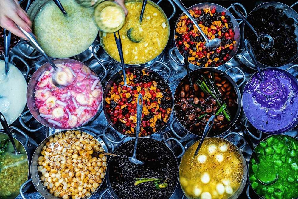 plusieurs cocottes de che de couleurs différentes dans un marché de Hue