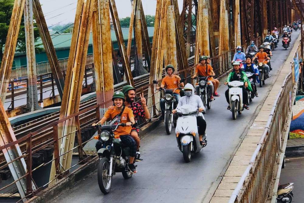 des moto minsk vintage traversant un pont ancien à Hanoi