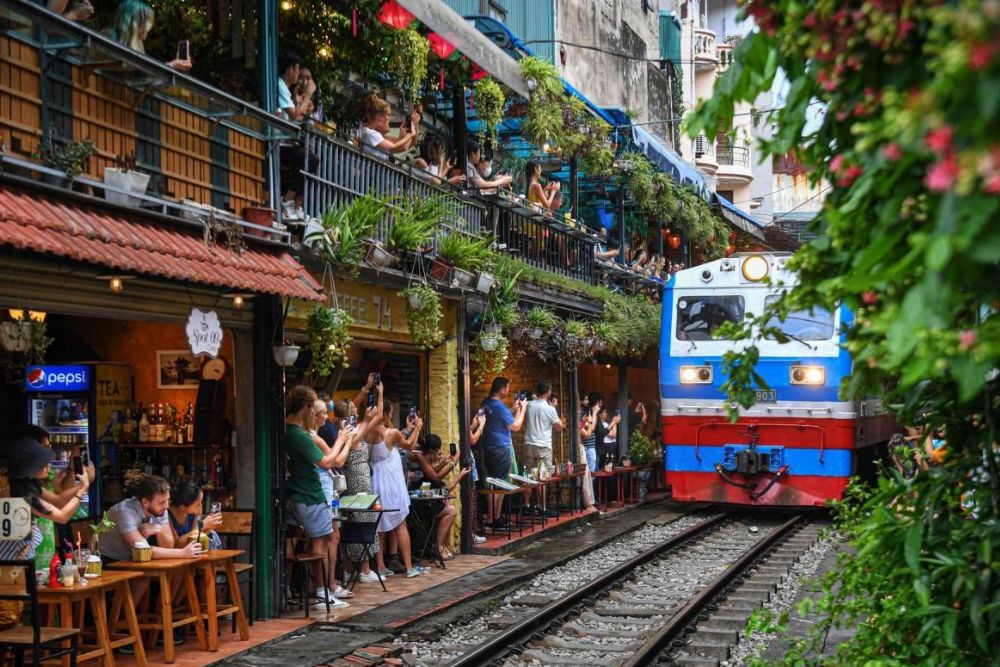 rue du train hanoi, un train passant par des cafés avec touristes, voyage vietnam