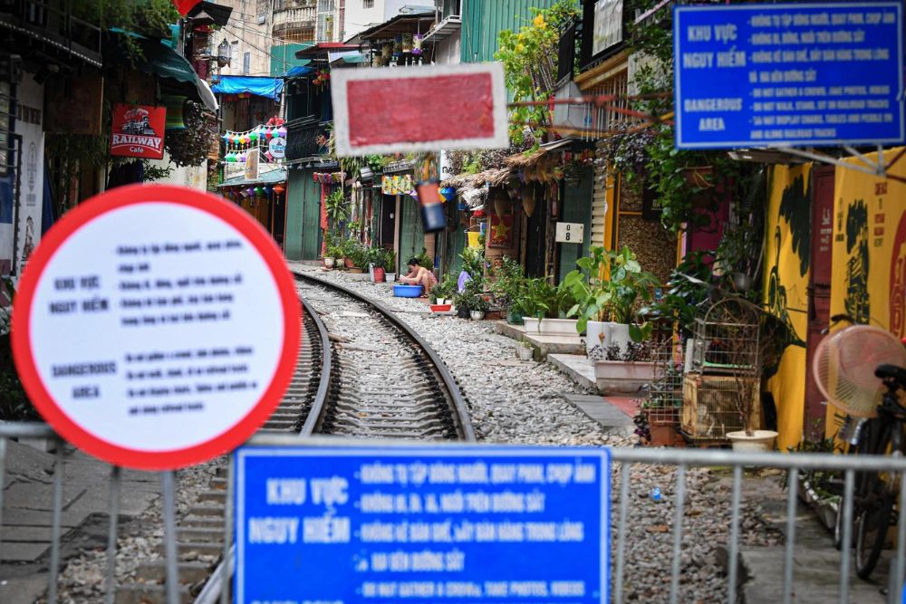 rue du train hanoi, rue du train fermée avec des barrières et panneaux, voyage vietnam