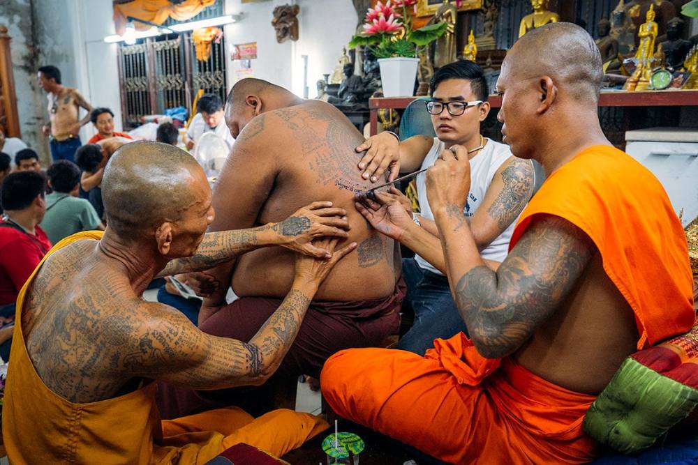 homme se fait tatouer par un moine dans un temple, tatouage thailande, sak yant