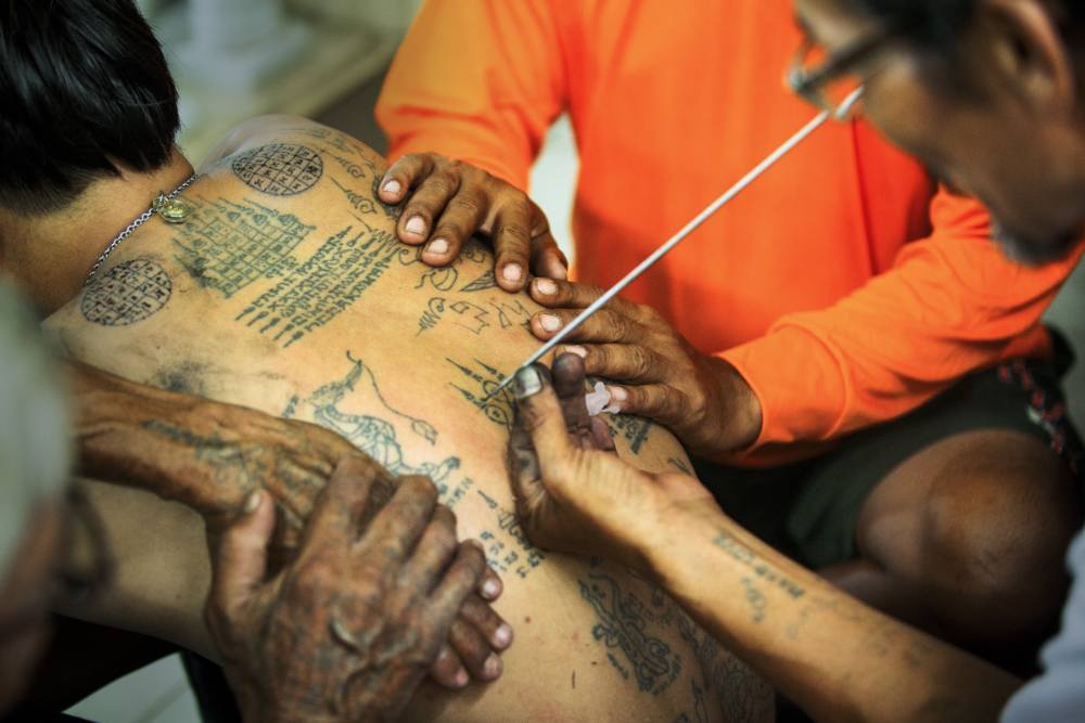 un maître tatoueur en travail, tatouage thailande, sak yant