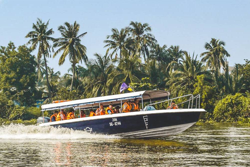 des voyageurs se rendent aux tunnels de Cu Chi en bateau